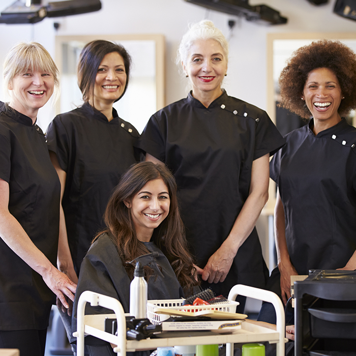 Group of woman hairstylists styling a women's hair