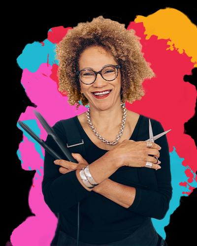 Woman stylist holding scissors and flat iron with a bright coloured graphic behind her