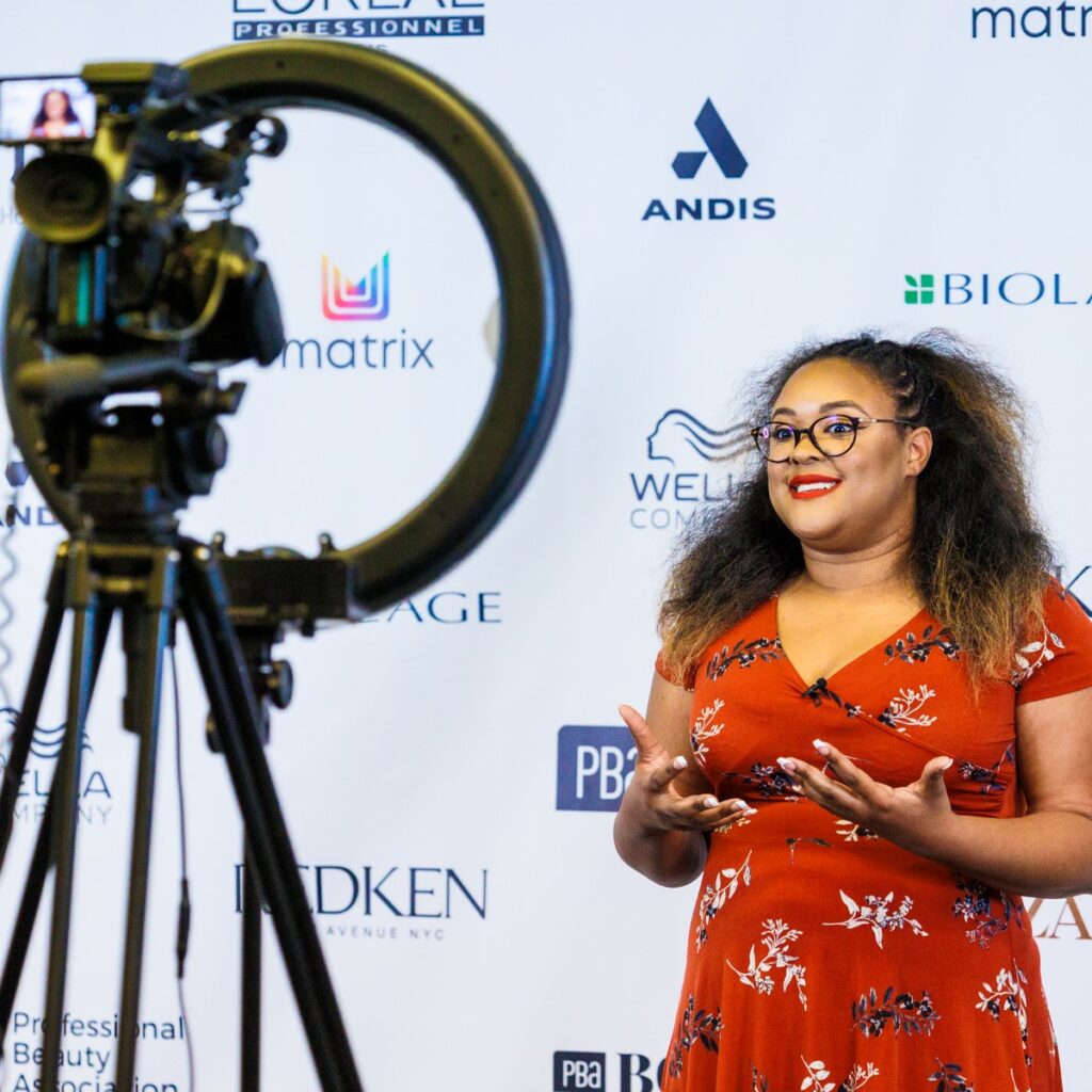 Image of a woman in a red dress in front of a camera