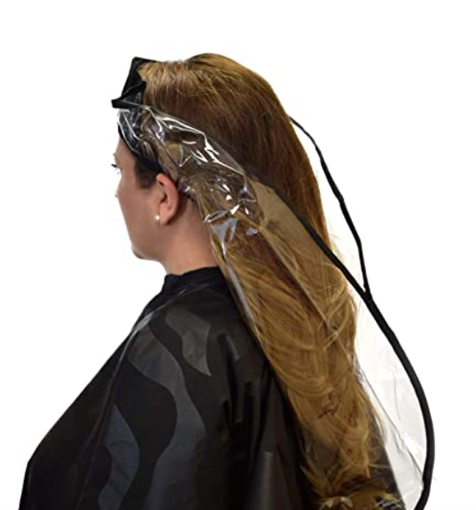 Image of a woman wearing a black cape getting her hair done