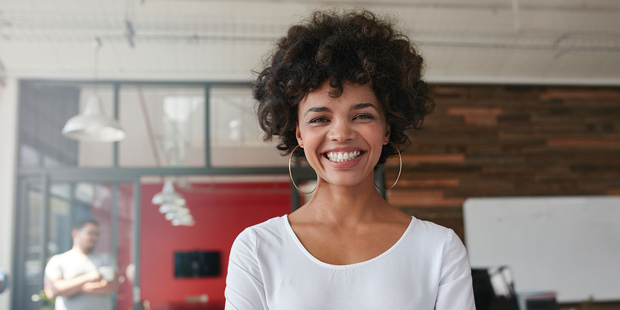 Woman smiling wearing large gold hoop earrings