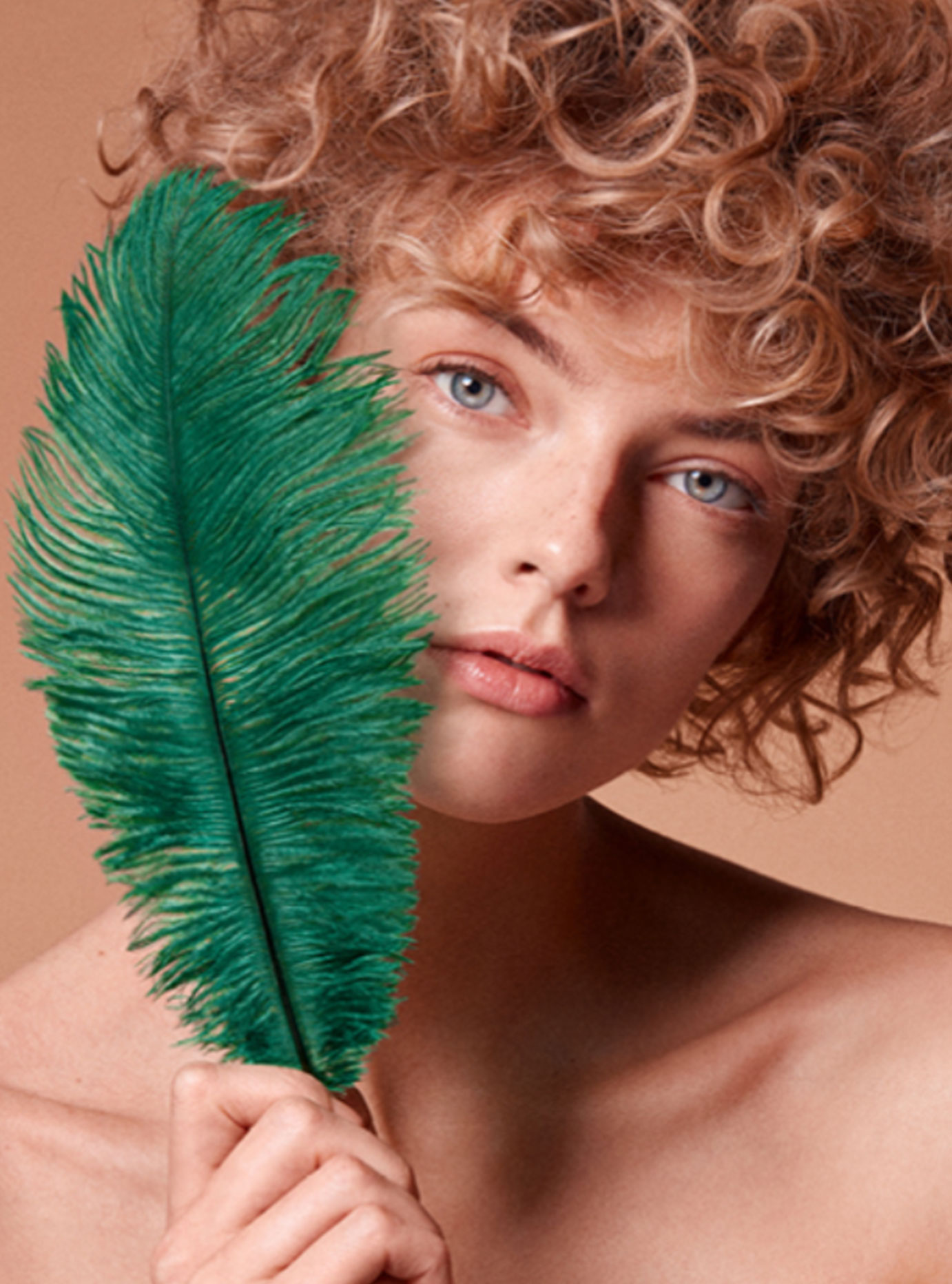 Image of woman holding a teal feather