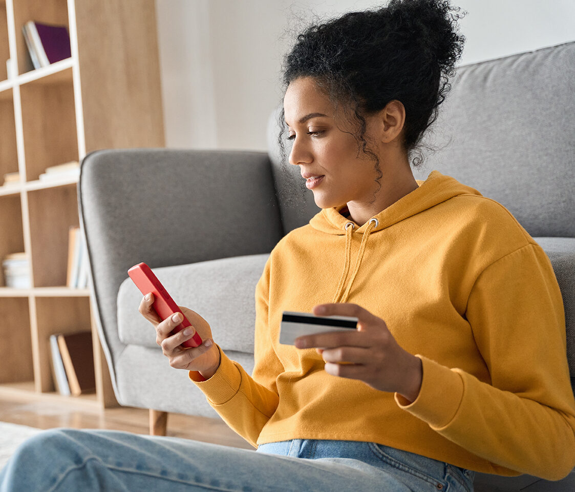 Image of a woman looking at her phone and card